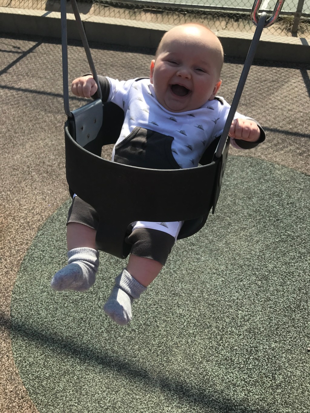 infant in swing and smilng